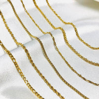 Goldene Halsketten auf weißem Stoff, Schmuck, Ketten, Modeaccessoires, glänzend, elegant.