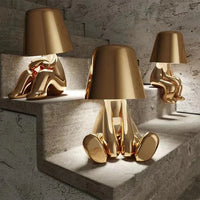Goldene Designer-Tischlampen in menschlicher Form auf Treppe, moderne Wohnkultur.