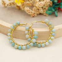 Goldene Creolen mit blauen Perlen, handgefertigter Schmuck, elegantes Design, Geschenkidee.