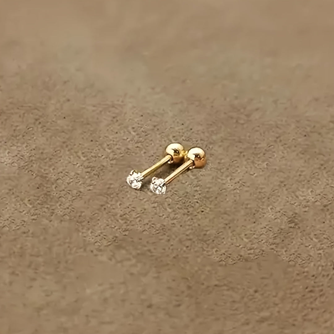 Goldene Ohrstecker mit Diamanten auf beigem Hintergrund, eleganter Schmuck für Damen.