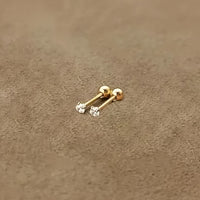 Goldene Ohrstecker mit Diamanten auf beigem Hintergrund, eleganter Schmuck für Damen.