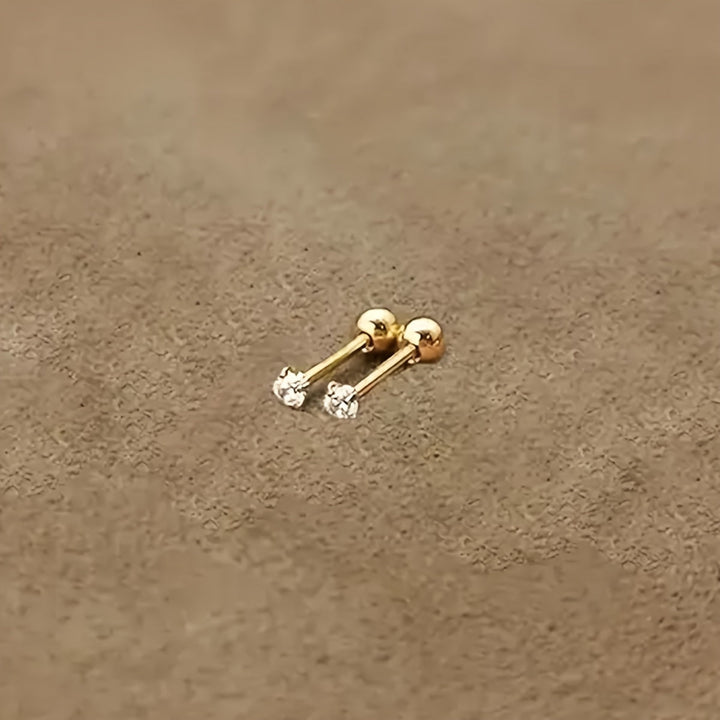 Goldene Ohrstecker mit Diamanten auf beigem Hintergrund, eleganter Schmuck für Damen.