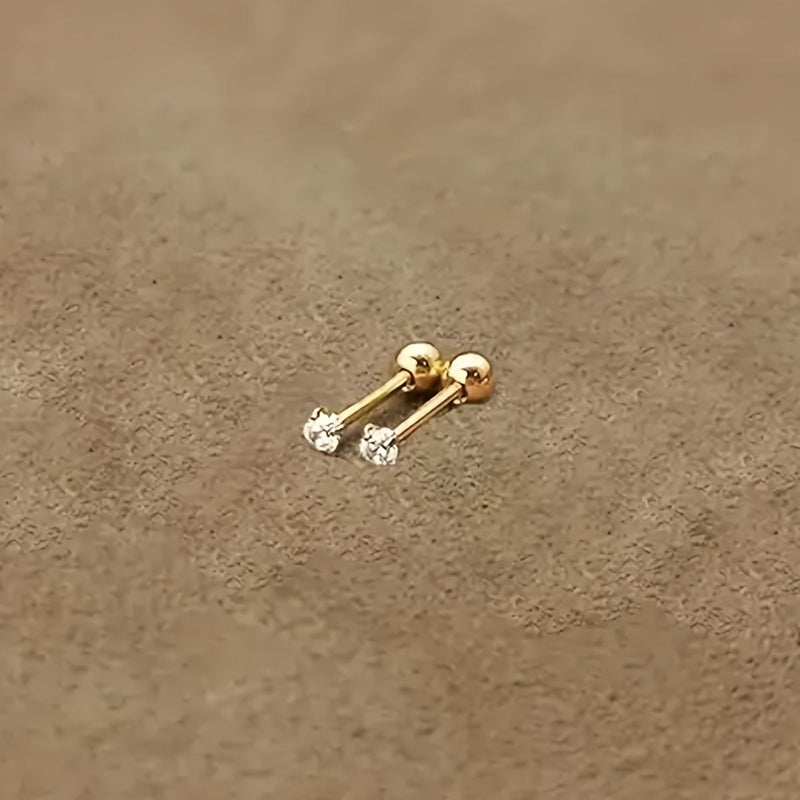 Goldene Ohrstecker mit Diamanten auf beigem Hintergrund, eleganter Schmuck für Damen.