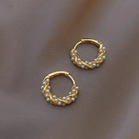 Goldene Creolen mit Perlen, eleganter Schmuck, modische Ohrringe, Damenaccessoire.