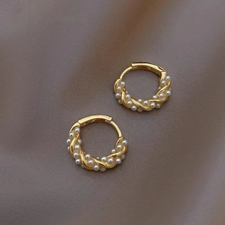 Goldene Creolen mit Perlen, eleganter Schmuck, modische Ohrringe, Damenaccessoire.