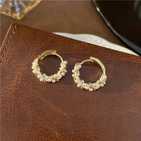 Goldene Creolen mit Perlen, eleganter Schmuck, modische Ohrringe, Damenaccessoire.