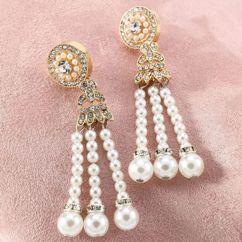 Goldene Ohrringe mit Perlen und Strasssteinen auf rosa Hintergrund, eleganter Schmuck.