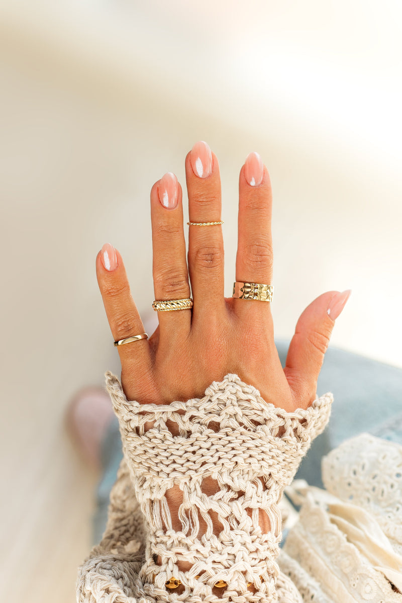 Hand mit goldenen Ringen, gehäkelte Spitze, elegante Damenmode, Schmuck, stilvoll, modisch.