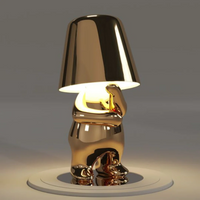 Goldene Tischlampe in Form eines nachdenklichen Bären, modernes Design, warmes Licht.