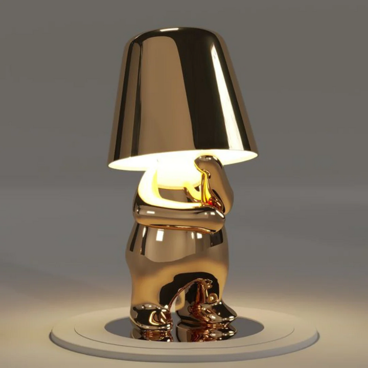 Goldene Tischlampe in Form eines nachdenklichen Bären, modernes Design, warmes Licht.