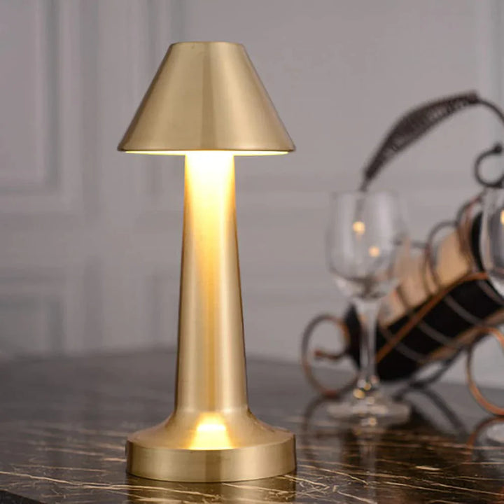 Goldene Tischlampe aus Metall, modernes Design, warmes Licht, ideal für Wohnzimmer oder Büro.