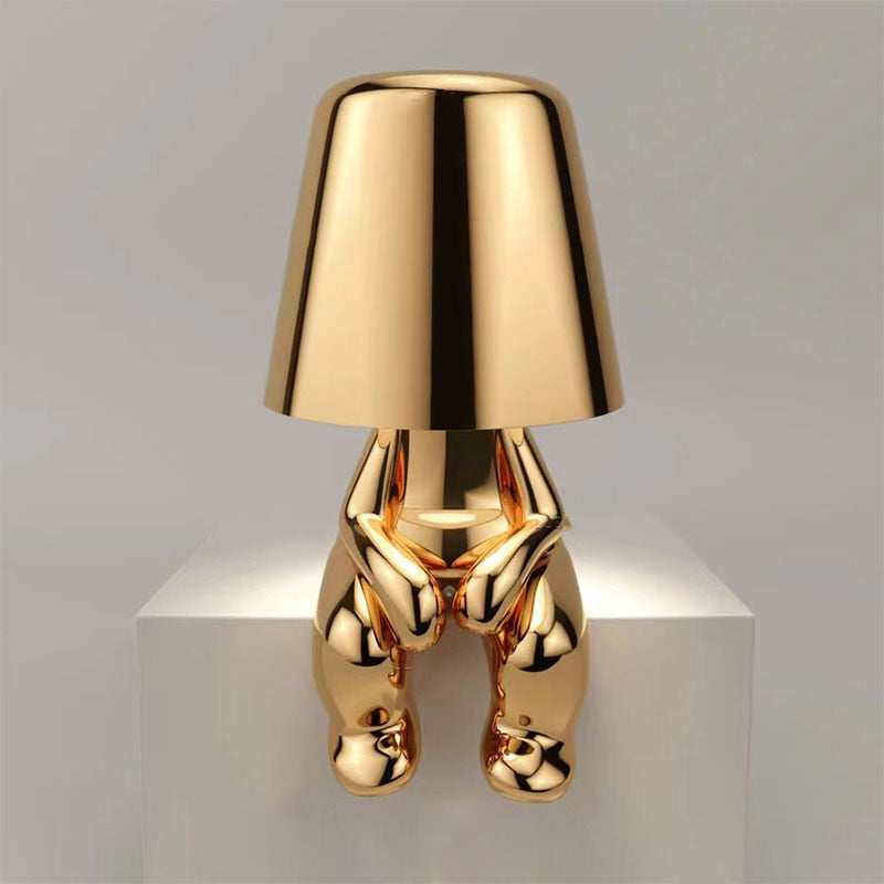 Goldene Designer-Tischlampe in menschlicher Form, modernes Kunstobjekt, glänzend, stilvoll.