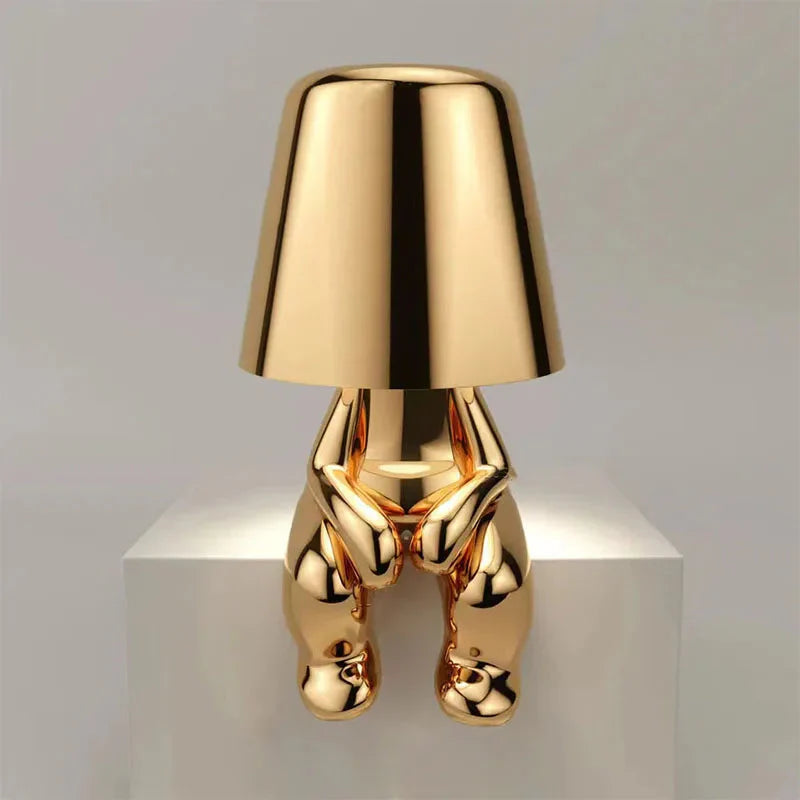 Goldene Designer-Tischlampe in menschlicher Form, modernes Kunstobjekt, glänzend, stilvoll.