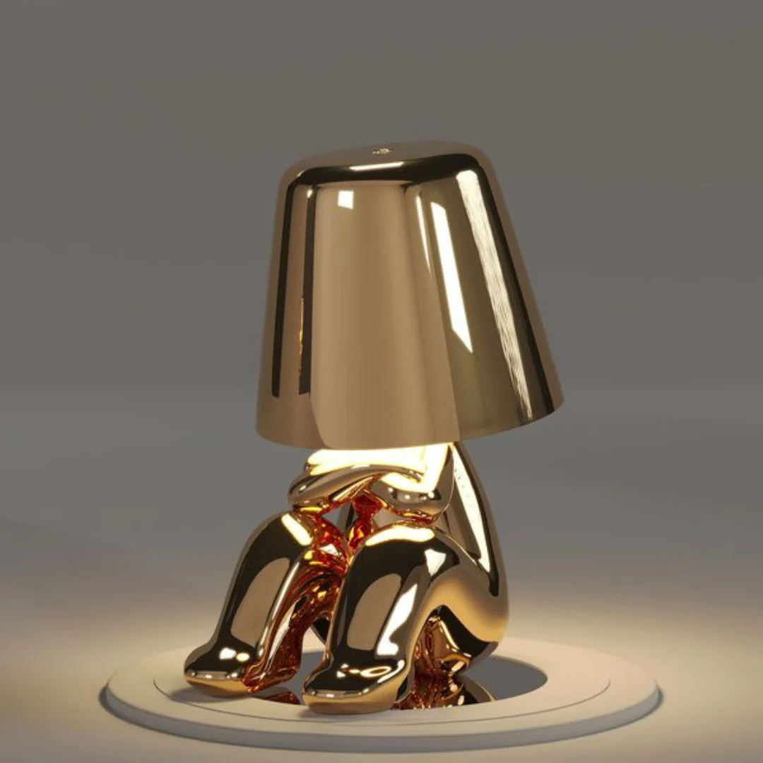 Goldene Tischlampe in Form einer sitzenden Figur, modernes Design, glänzend, dekorativ.