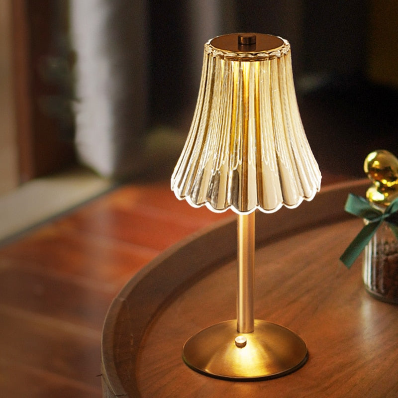 Goldene Tischlampe mit geriffeltem Lampenschirm, warmes Licht, elegantes Design, Wohnzimmer.