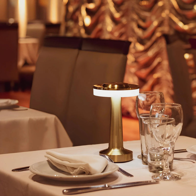 Goldene Tischlampe im Restaurant, modernes Design, elegante Beleuchtung, stilvolle Dekoration.