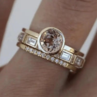 Goldener Verlobungsring mit rundem Diamant und rechteckigen Steinen, elegantes Schmuckdesign.