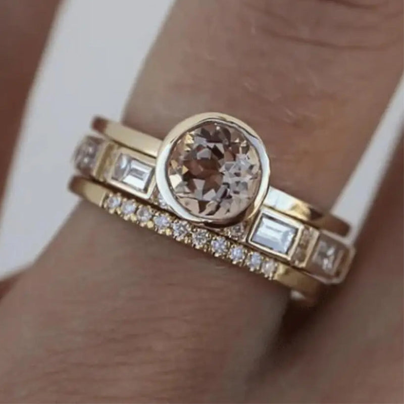 Goldener Verlobungsring mit rundem Diamant und rechteckigen Steinen, elegantes Schmuckdesign.