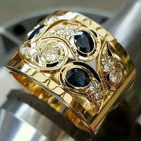 Goldener Ring mit blauen Saphiren und Diamanten, luxuriöses Schmuckdesign, glänzend.