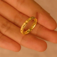 Goldener Ring auf Handfläche, gehämmertes Design, Schmuck, Damenring, modisch, elegant.