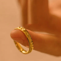 Goldener Ring mit gehämmerter Oberfläche, elegantes Schmuckdesign, Nahaufnahme auf Finger.
