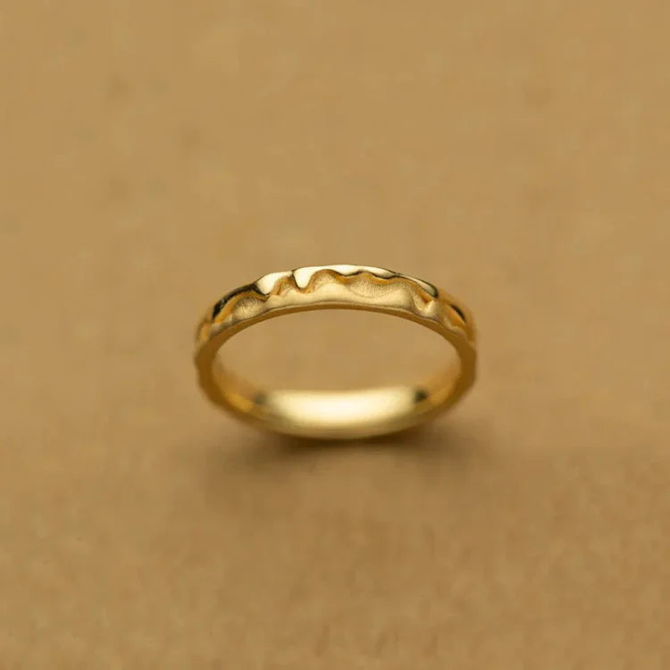 Goldener Damenring mit wellenförmigem Design, minimalistischer Schmuck, elegantes Accessoire.
