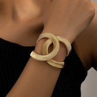 Goldenes Armband, ineinander verschlungen, elegantes Design, Damenmode, Schmuckaccessoire.