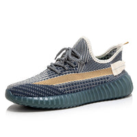 Grauer Sneaker mit gestricktem Obermaterial, blauer Sohle und gelbem Streifen, modische Herrenschuhe.