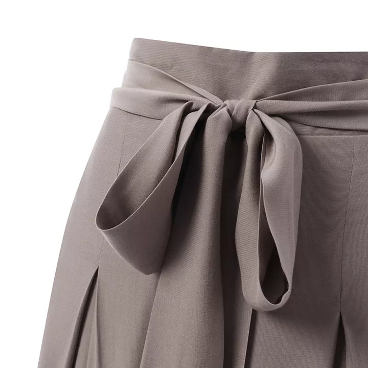 Graue Damenhose mit Schleife, Faltenrock-Design, eleganter Look, modische Damenbekleidung.