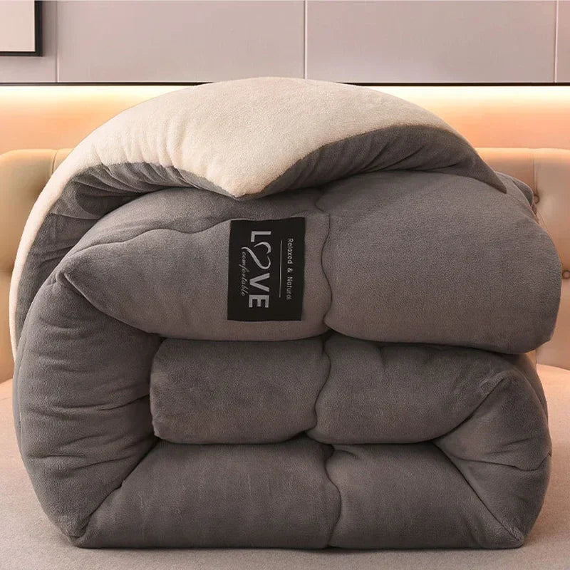 Graue, gefaltete Mikrofaser-Bettdecke auf Sofa, weiche Textur, modernes Design.