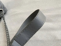 Grauer Lederriemen mit Kette, Nahaufnahme, hochwertige Handtasche, modisches Accessoire.