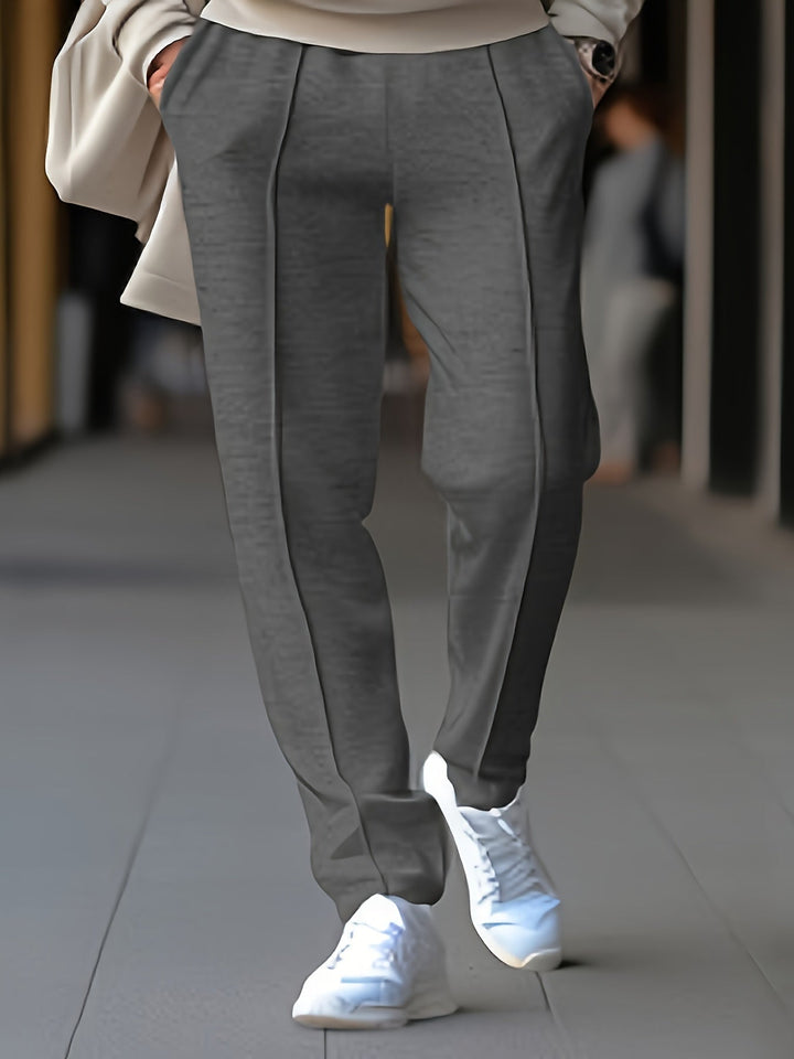 Graue Damenhose aus Wolle, elegant geschnitten, kombiniert mit weißen Sneakern.