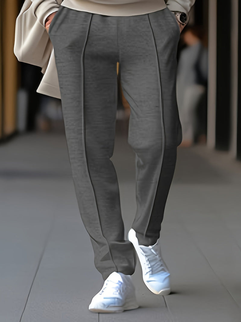 Graue Damenhose aus Wolle, elegant geschnitten, kombiniert mit weißen Sneakern.