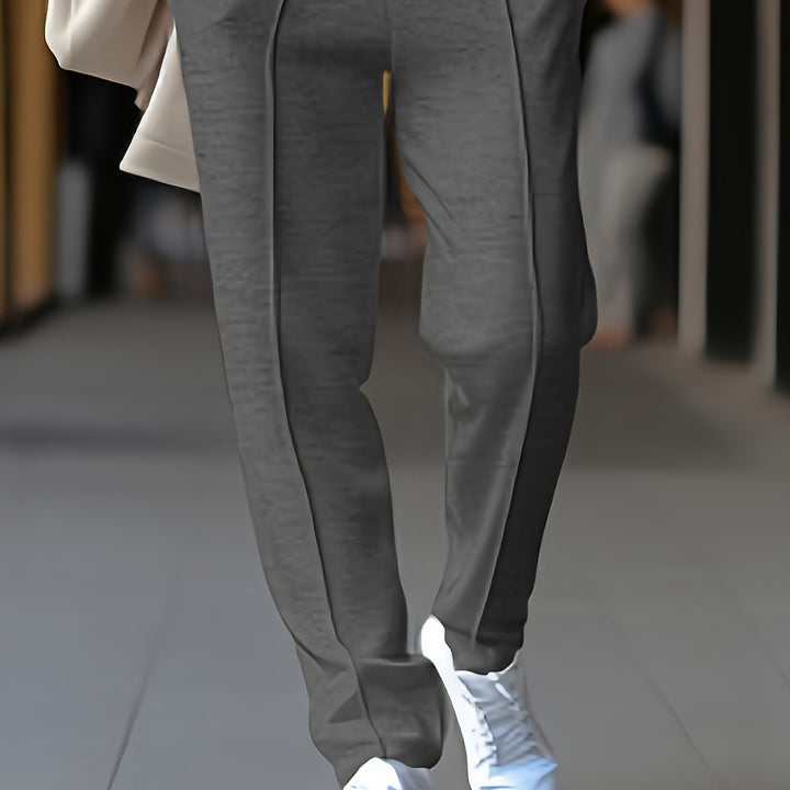 Graue Jogginghose aus Baumwolle, Herrenmode, lässig, bequem, mit weißen Sneakern.