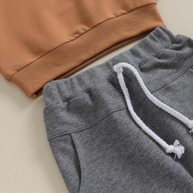 Graues Jogginghose mit weißem Kordelzug und braunem Sweatshirt, bequeme Freizeitkleidung.