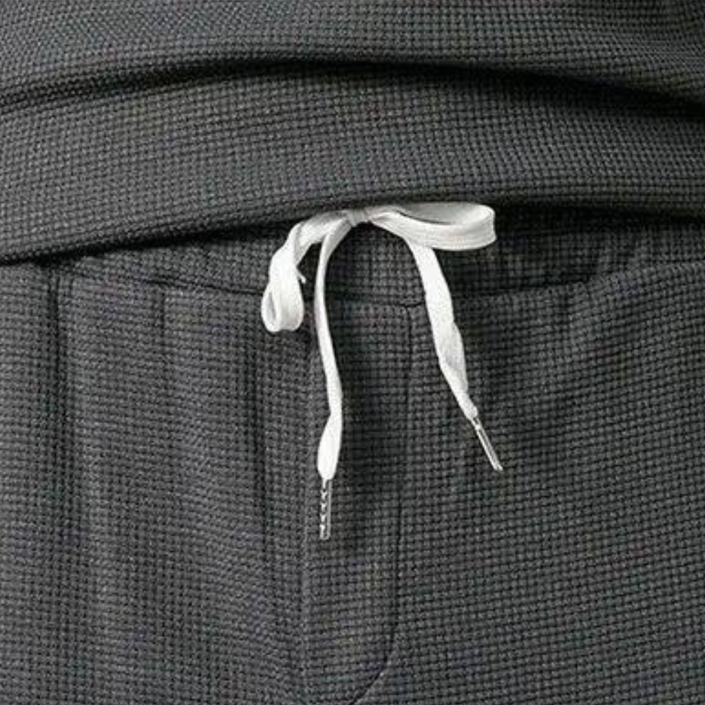 Graue Jogginghose mit weißem Kordelzug, Waffelstruktur, bequeme Freizeitkleidung.