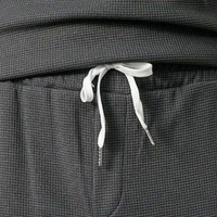 Graue Jogginghose mit weißem Kordelzug, Waffelstruktur, bequeme Freizeitkleidung.