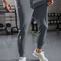 Graue Herren-Trainingshose, atmungsaktiv, elastisch, Fitnessstudio, Sportbekleidung, modern.