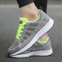 Grauer Sportschuh mit neongelben Akzenten, atmungsaktives Mesh, Damen Sneaker, Straßenlauf.