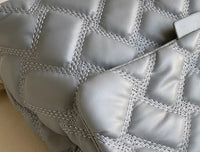 Graue gesteppte Ledertasche, quadratisches Muster, modisches Accessoire, Damenmode.