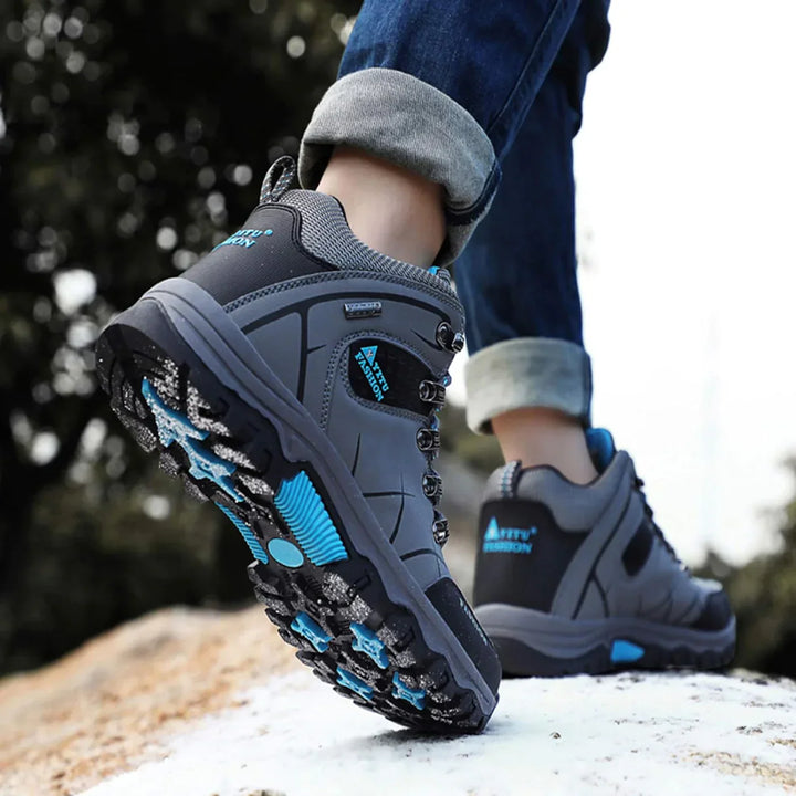 Graue wasserdichte Wanderschuhe mit blauen Akzenten, rutschfeste Sohle, Outdoor-Bekleidung.