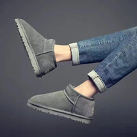 Graue Winterstiefel aus Wildleder, knöchelhoch, mit Jeans kombiniert, modisch und warm.