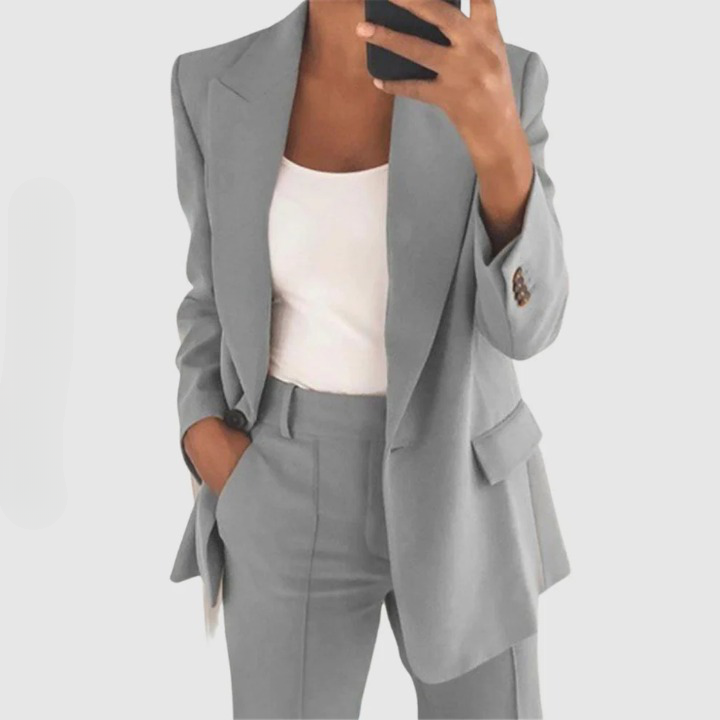 Grauer Damenanzug, Blazer und Hose, Businessmode, eleganter Look, weiße Bluse.