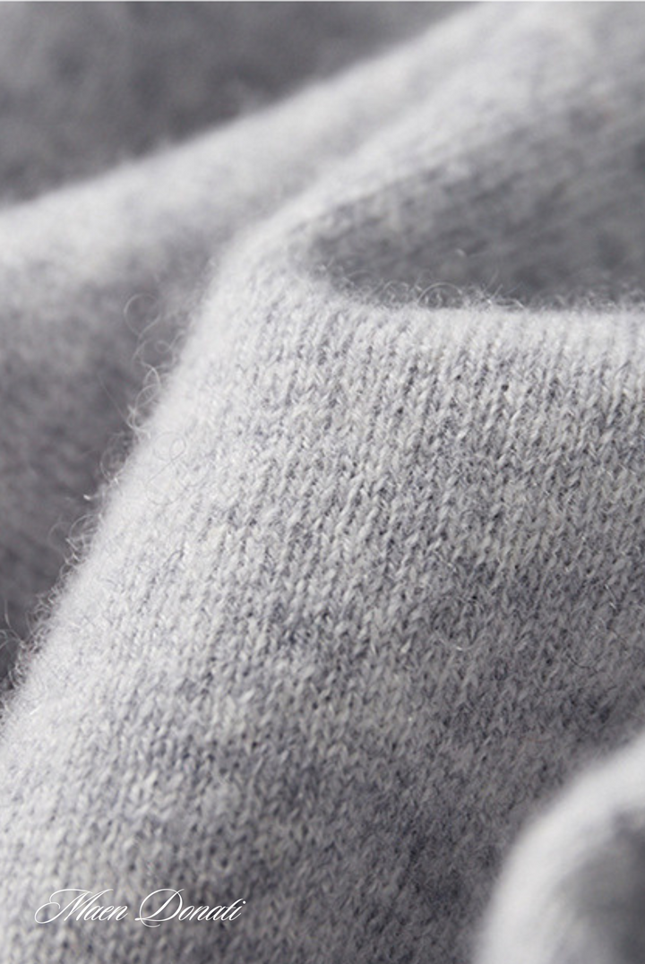 Grauer Kaschmirpullover Stoff, weiche Textur, luxuriöses Material, Nahaufnahme.