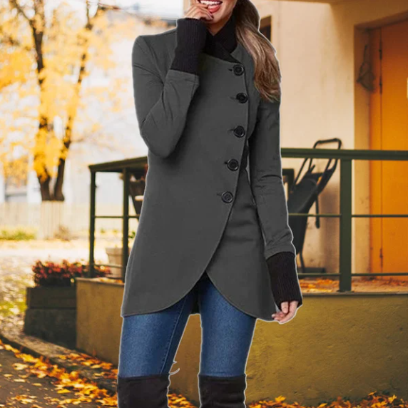 Frau in grauem Mantel, Herbst, Jeans, Stiefel, stilvolle Herbstmode, draußen, Laub im Hintergrund.