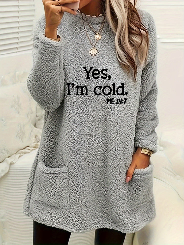 Frau in grauem Fleece-Pullover mit Aufschrift "Yes, I'm cold", gemütliche Wintermode.