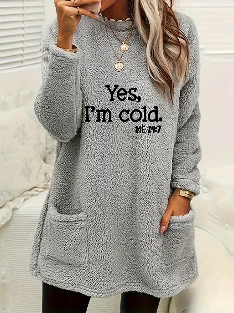 Frau in grauem Fleece-Pullover mit Aufschrift "Yes, I'm cold", gemütliche Wintermode.