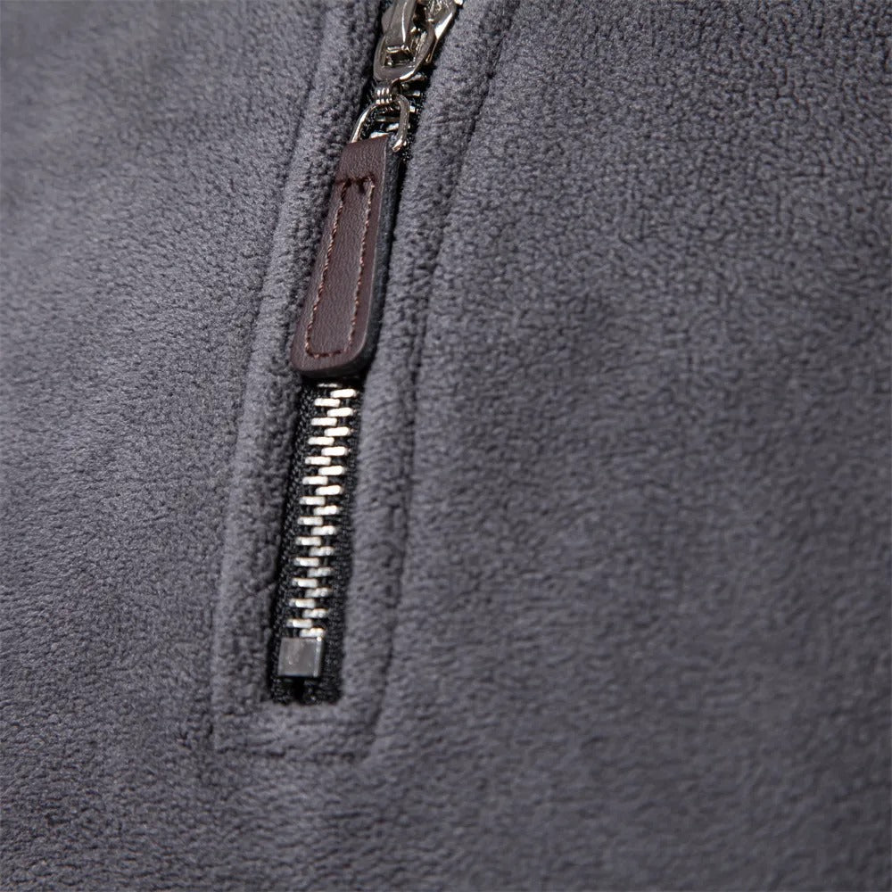 Grauer Fleece-Pullover mit Reißverschluss, weiches Material, warme Herrenmode, Detailansicht.