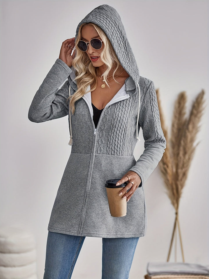 Frau in grauem Kapuzenpullover mit Kaffeebecher, Sonnenbrille, Jeans, modisch, lässig.