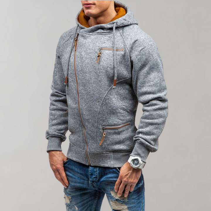 Mann in grauem Hoodie mit Reißverschlüssen, Jeans, Armbanduhr, modisch, lässiger Stil.